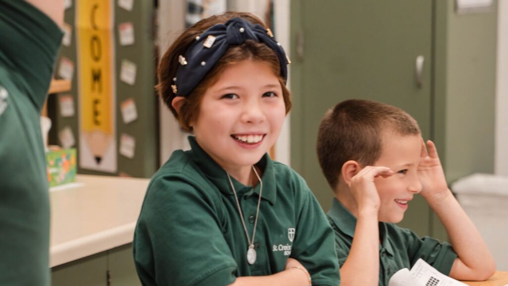 3rd grade girl smiling at desk